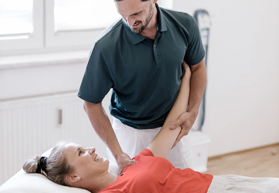 Woman on a table having her shoulder inspected by a therapist